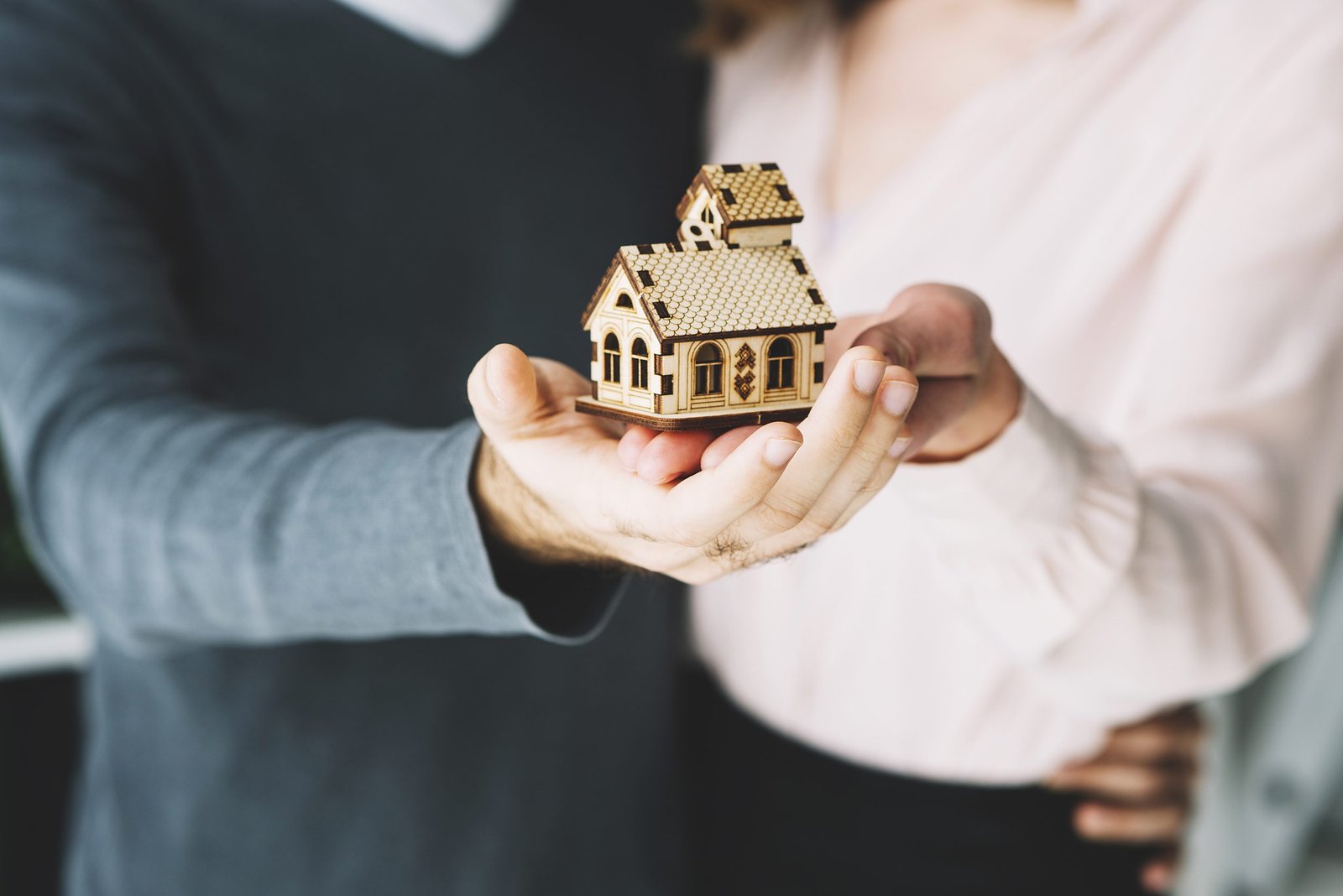Pareja sosteniendo una maqueta de un edificio
